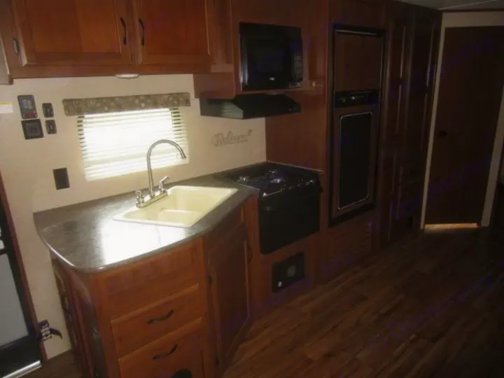 RV rental kitchen: a compact space with sink, stove, microwave, and fridge for on-the-go cooking.. Jay Flight 287 BHSW 2016