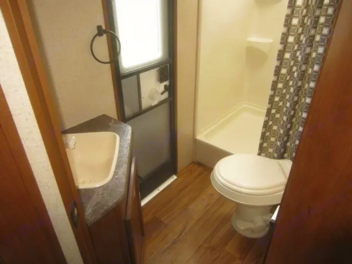 This RV rental features a compact bathroom with a corner sink, toilet, and shower, offering all essential amenities.. Jay Flight 287 BHSW 2016