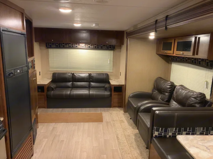 Modern RV rental interior with a comfortable sofa, two armchairs, and ample overhead storage for your next adventure.. Coleman Lantern 2018