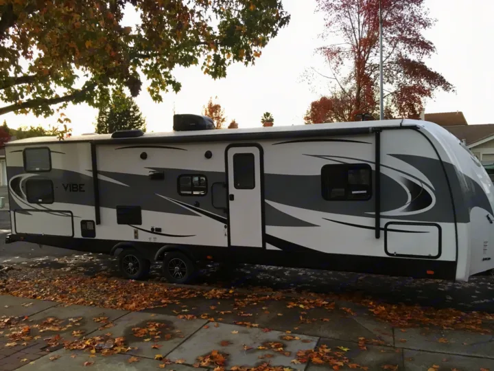 Spacious RV rental, a Vibe travel trailer, parked outdoors with autumn leaves on the ground, ready for a fall adventure.. Forest River Vibe 2018