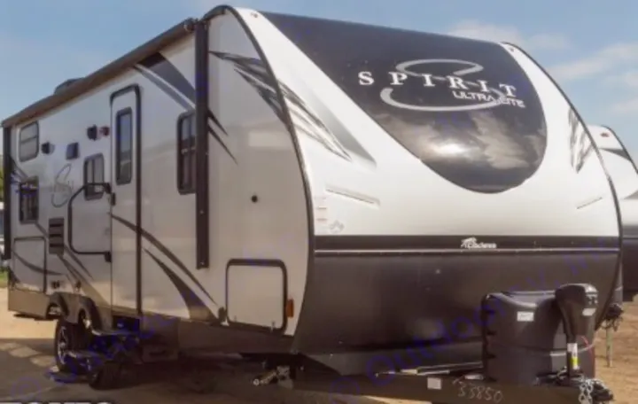 White and black Spirit Ultra-Lite travel trailer, ideal for an RV rental. Parked outdoors, ready for adventure.. Coachmen Spirit Of America 2019