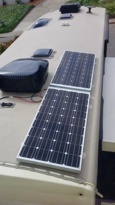 Top-down view of an RV rental roof featuring two large solar panels and other amenities, ideal for off-grid adventures.. Forest River Cardinal 2017