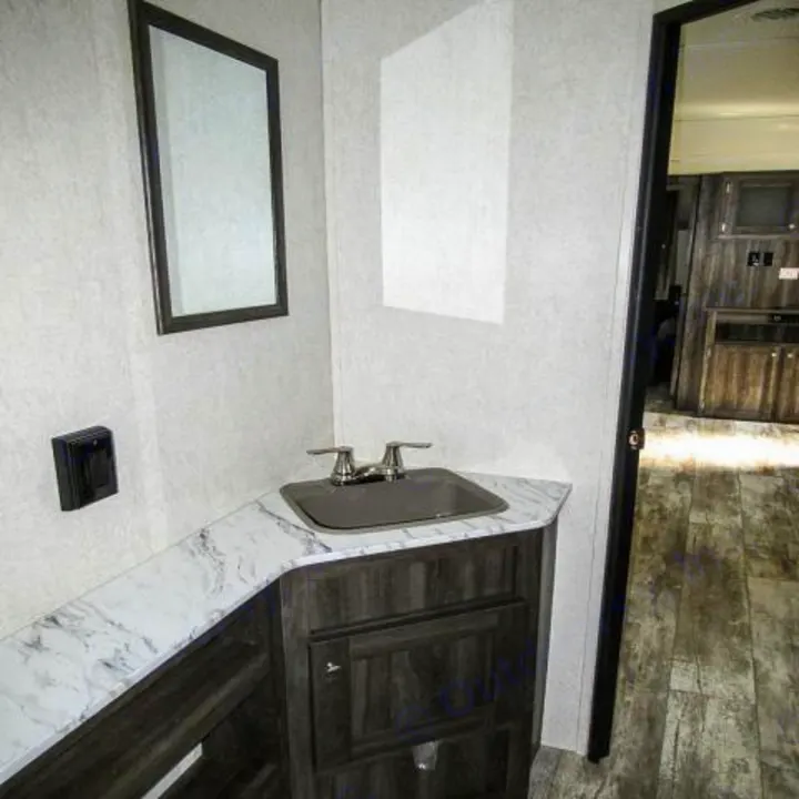 RV rental bathroom: sink, faucet, mirror, dark vanity, and marbled countertop.. Openrange 26BHS 2020