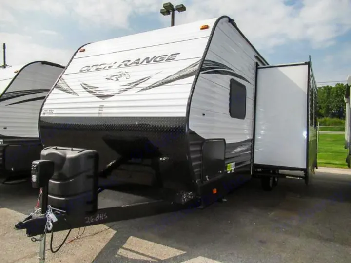 A white and black Open Range travel trailer is shown, with a side slide-out extended. This RV is ready for rental adventures.. Openrange 26BHS 2020