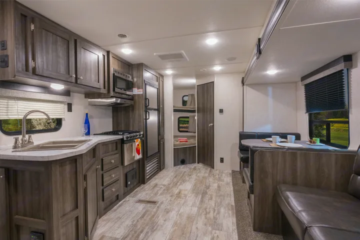 Step into this bright RV rental, showcasing a modern kitchen, spacious dinette, and cozy bunk beds for your travels.. Openrange 26BHS 2020