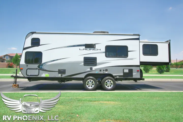 White and gray "LAUNCH" travel trailer RV rental, showcasing an extended slide-out for extra living space.. Starcraft Launch 19BHS 2017