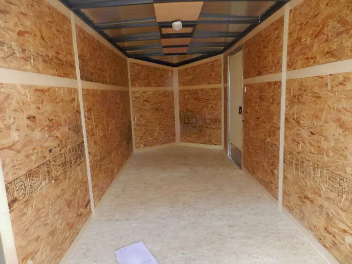 Spacious, empty enclosed trailer interior with OSB walls & floor, ready for rv rental or storage.. Look Enclosed V-Nose W/Ramp Door 2016