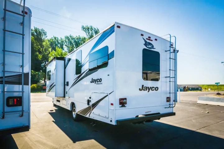 Explore the open road! This white Jayco RV, ready for rv rental, features a rear ladder and slide-out section.. Jayco Redhawk 31 XL 2019