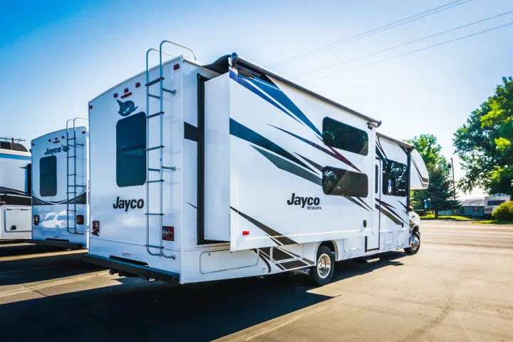 Jayco Redhawk RV rental, seen from rear-side, with extended slide-out & ladder, parked in a sunny lot.. Jayco Redhawk 31 XL 2019