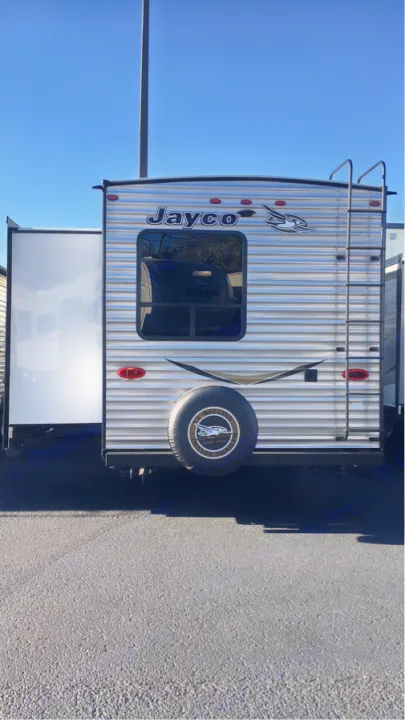 Rear view of a silver Jayco travel trailer (RV) with a slide-out and ladder. Perfect for your next rv rental adventure!. Jayco Flight 2018