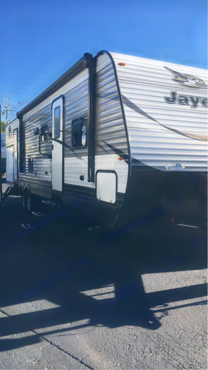 Jayco RV rental: A modern travel trailer with an awning, ready for adventure under a clear blue sky.. Jayco Flight 2018