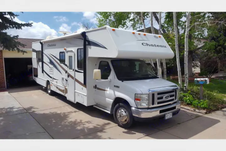 White Chateau RV rental, a Class C motorhome, parked in a sunny driveway, ready for adventure.. Ford E450 Fourwinds Chateau 2010