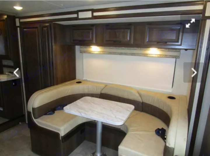 RV rental: Bright U-shaped dinette with upholstered seating, table, and overhead wood cabinets. Ideal for journeys.. Mercedes-Benz 313 Sprinter LWB Motorhome 2018
