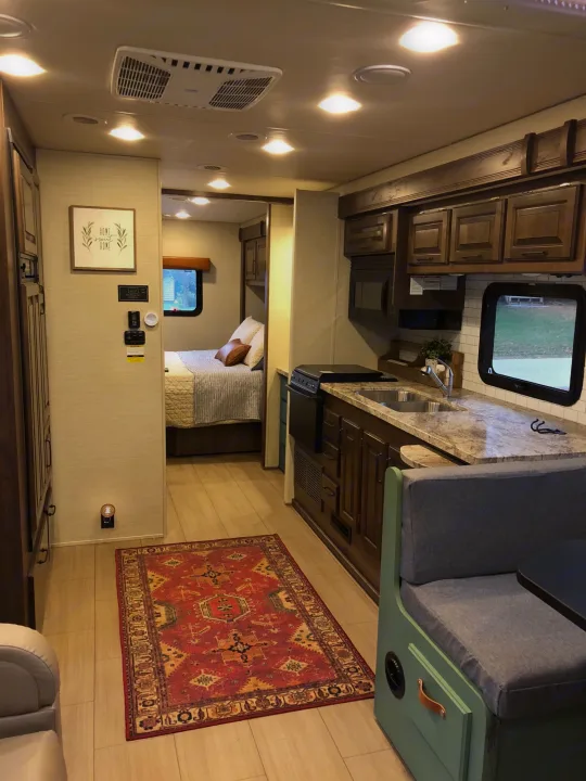 Spacious RV rental interior featuring a modern kitchen, dinette, and cozy bedroom. Perfect for travel adventures.. Jayco Greyhawk 2018