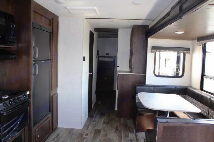 Modern RV rental interior showcasing a kitchen, spacious dining booth, and hallway leading to private areas.. Starcraft Autumn Ridge 2018