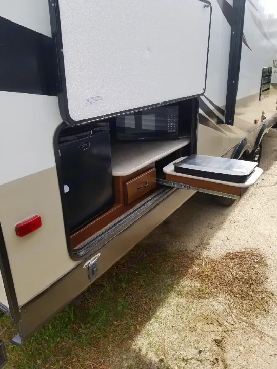 This RV rental features a convenient outdoor kitchen with a microwave, fridge, and pull-out griddle for easy campsite cooking.. Jayco White Hawk Ultra Lite 2015