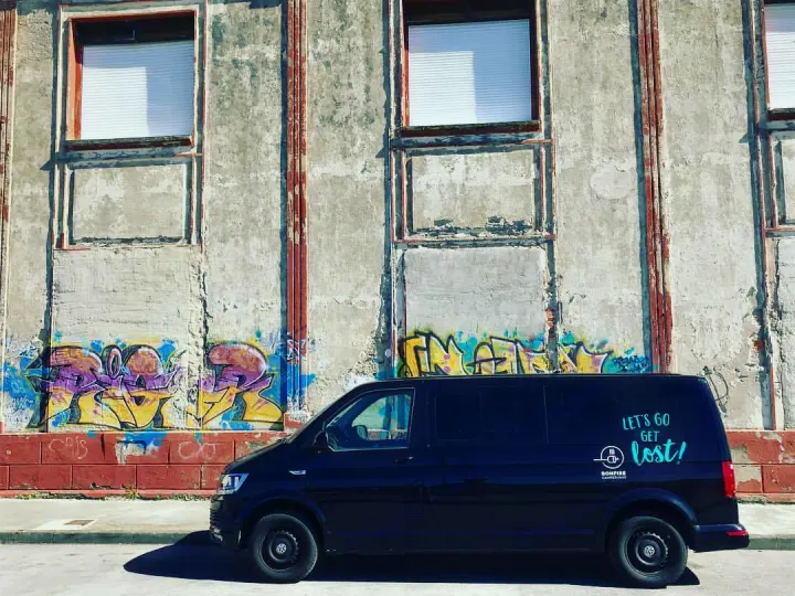 Black camper van for RV rental, parked by a graffiti-covered wall. "LET'S GO GET lost!" on the side.. Volkswagen Caravelle Long 2019