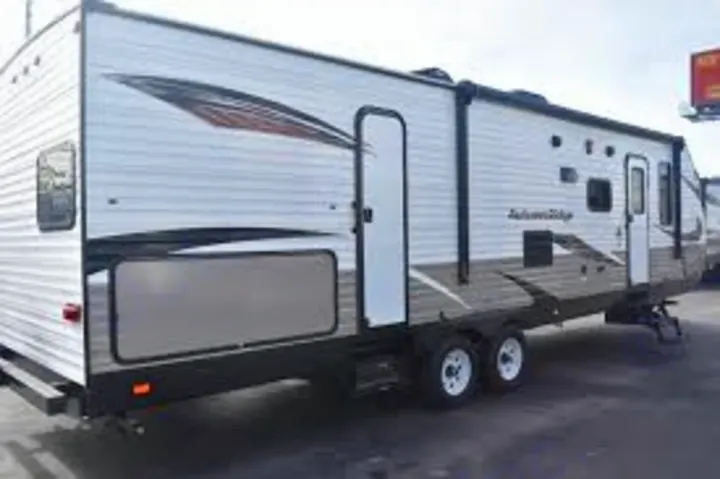 A spacious white and gray travel trailer, ideal for RV rental camping trips or a family road trip.. Starcraft Autumn Ridge 2018