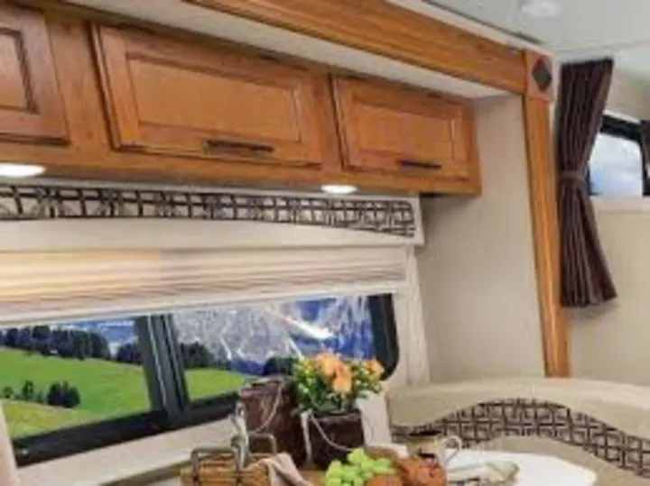 RV rental interior: A cozy dining area with wooden cabinets and a stunning mountain view from the window. Enjoy comfortable travel!. Jayco Melbourne 2017