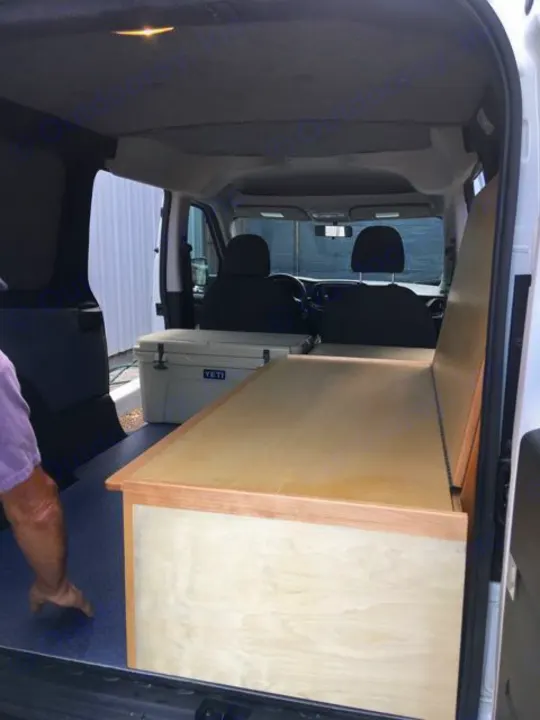 RV rental: Van interior with custom bed/storage, Yeti cooler, and blue floor mat.. ram promaster city 2018
