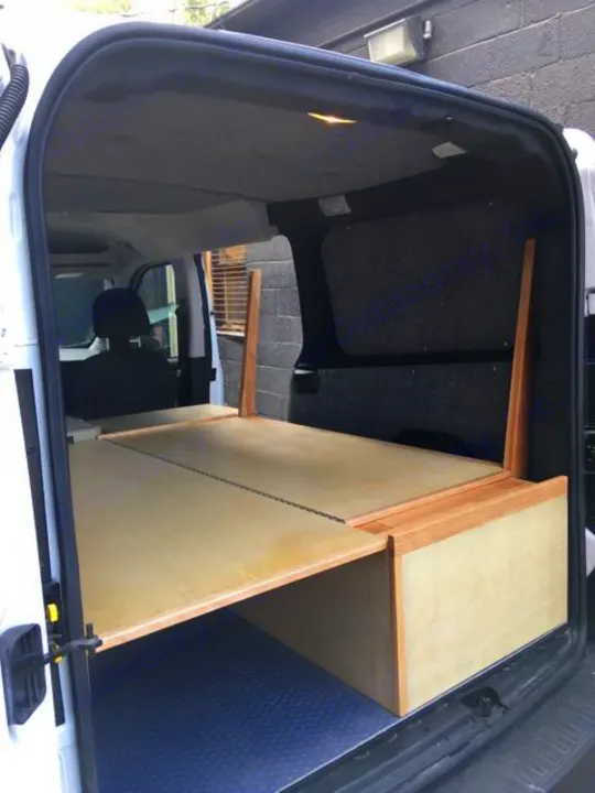 Explore this RV rental's clever van conversion: a light wood bed platform with ample under-bed storage for mobile living.. ram promaster city 2018