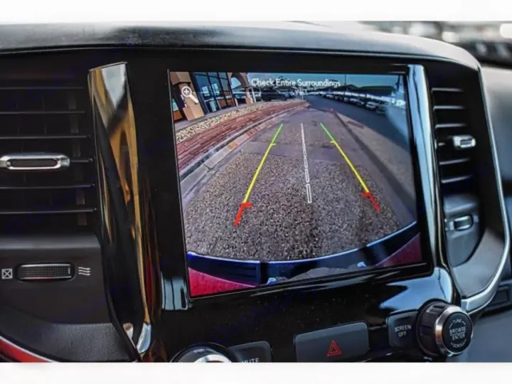 RV rental's backup camera view on infotainment screen, showing parking assistance lines on a dashboard.. ram 1500 bighorn 2019