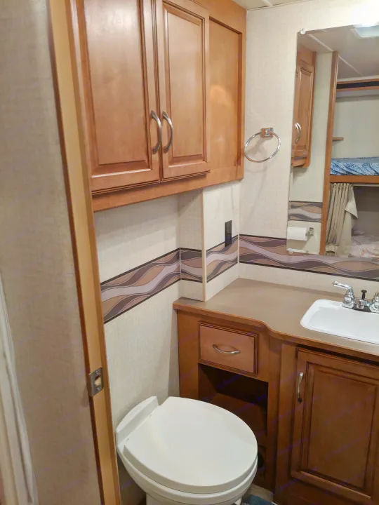 bathroom view: sink and toilet shown, shower on the right just out of view. more cabinet space in here. . Winnebago Minnie Winnie 2017