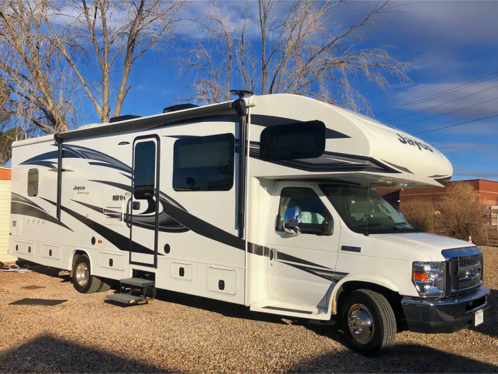 White Jayco Greyhawk Class C motorhome, perfect for an rv rental, parked on gravel with clear skies.. Jayco Greyhawk 2018