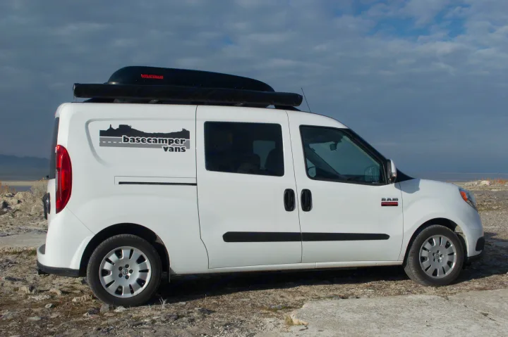 White Ram ProMaster City camper van RV rental with rooftop cargo box & awning, parked for outdoor adventure.. ram promaster city 2018