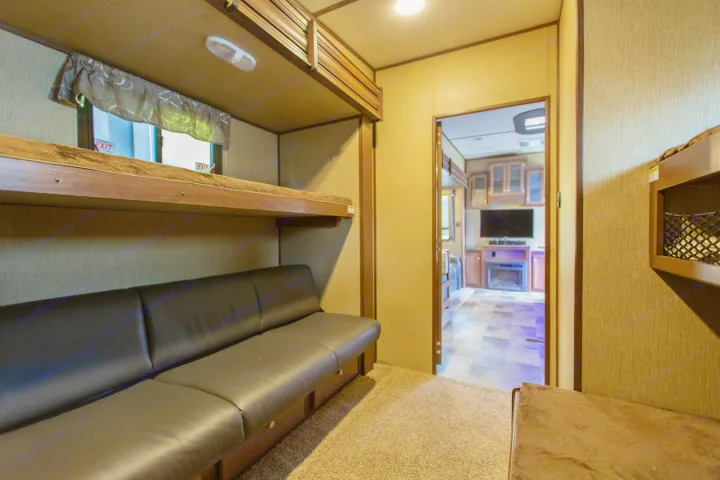 Spacious RV rental interior: Bunk beds & convertible sofa leading to a living area with TV and fireplace.. sprinter keystone 2018