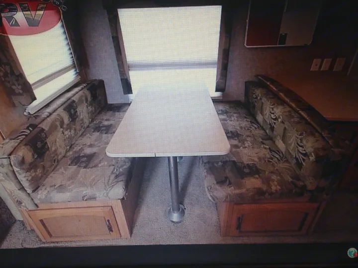 This RV rental features a cozy dinette area with opposing upholstered benches, a table, and under-seat storage.. Palomino Puma 2010