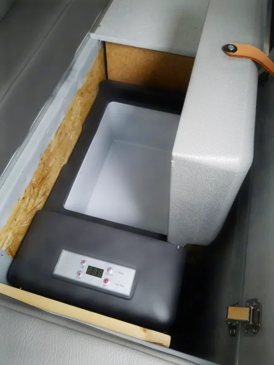Portable refrigerator/cooler, open and empty, set into a camper van's built-in storage for your RV rental adventures.. Ford Transit Custom 2017