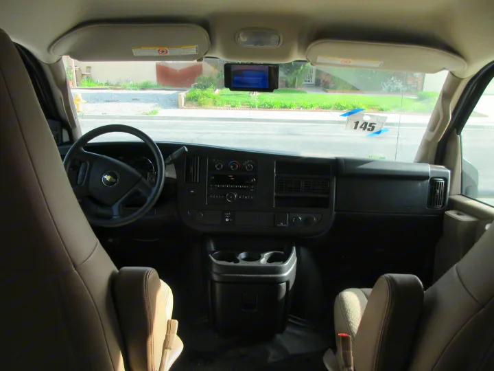 View of an RV rental's front cabin. The dashboard with Chevy steering wheel, controls, and front seats are clearly visible.. Jayco Redhawk 2018