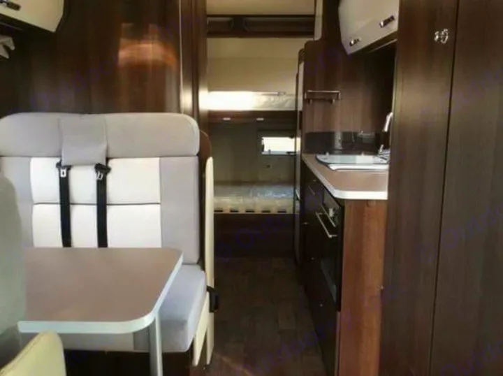RV rental interior shows a compact kitchen, dining/seating area with seatbelts, and a sleeping area in the back.. Other Transit Motorhome 2018
