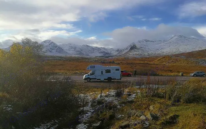 An RV rental is parked on a roadside with majestic snow-capped mountains and a vast winter landscape in the background.. Other Transit Motorhome 2018