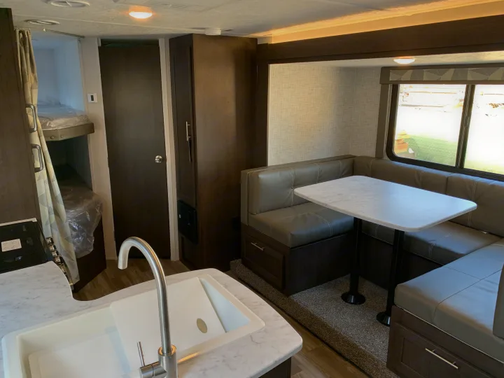 Spacious RV rental interior featuring a modern kitchen, comfortable dinette, and bunk beds for travel.. Forest River Cruise Lite 2020