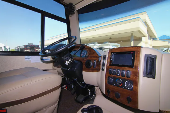This RV rental's driver's seat and dashboard are ready for your next journey, featuring steering wheel, controls, and multimedia screen.. Thor Hurricane 2018