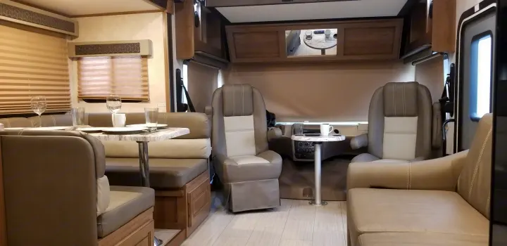 Spacious RV rental interior: modern dining area, front captain's chairs, and cabinets. Bright, clean living space.. Forest River Fr3 2021