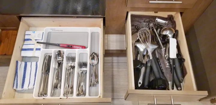 Organized kitchen drawers in an RV rental, showing flatware, dishtowels, and various cooking utensils for convenient storage.. Forest River Fr3 2021