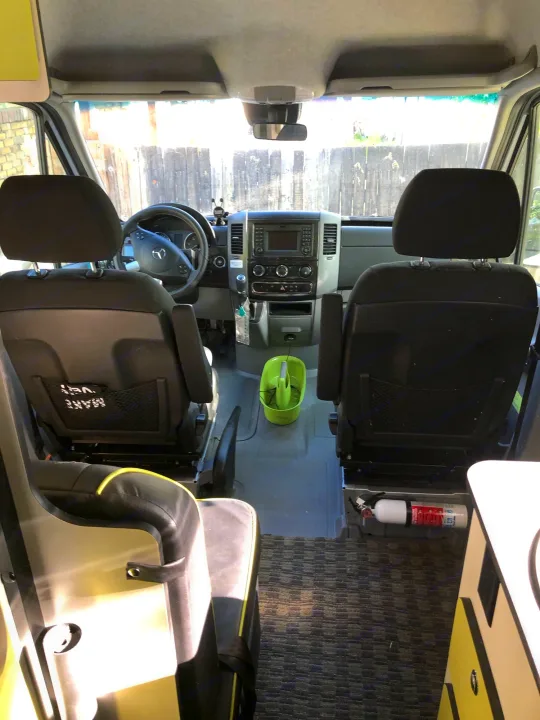 Explore this RV rental's cozy interior: front seats, dashboard, and fire extinguisher for a safe journey.. Winnebago Mercedes Sprinter 2019