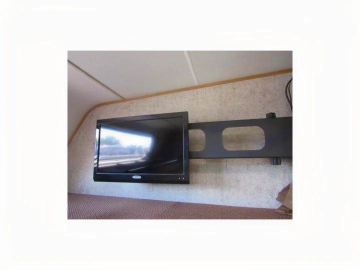 RV rental: Wall-mounted TV in an RV interior, with a black bracket and textured surface visible below.. Forest River Coachmen Leprechaun 2017