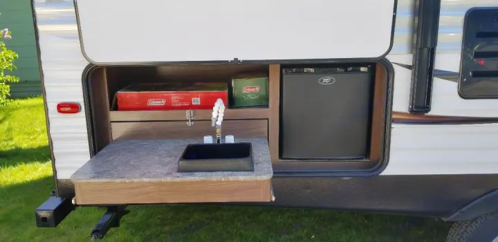 This RV rental offers an outdoor kitchen with a sink, minifridge, and storage shelves.. Coleman Other 2017