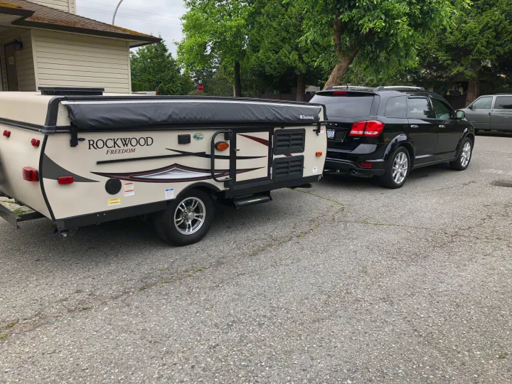 RV rental: Black SUV towing a Rockwood pop-up camper, ready for your next travel adventure.. Forest River Rockwood 2017