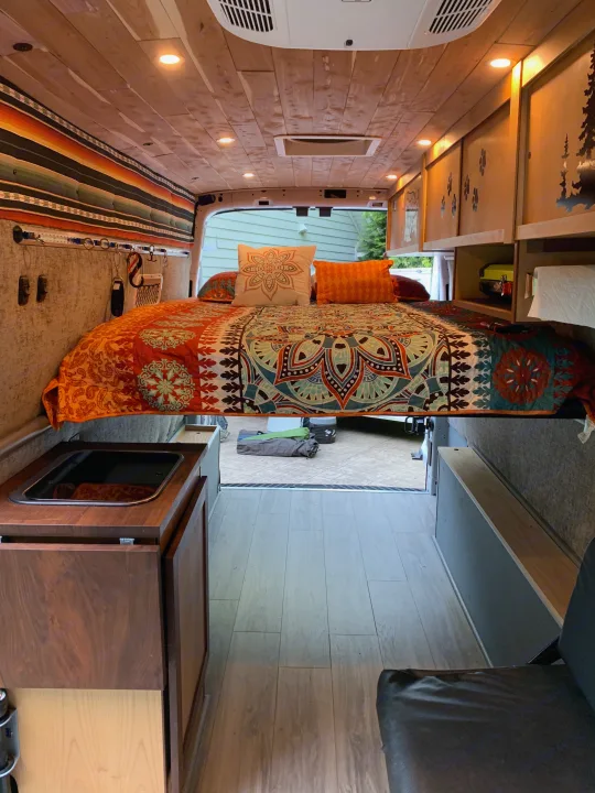 Queen sized bed with 4" memory foam mattress, all linens/pillows included with rental. Ford Transit Custom 2017