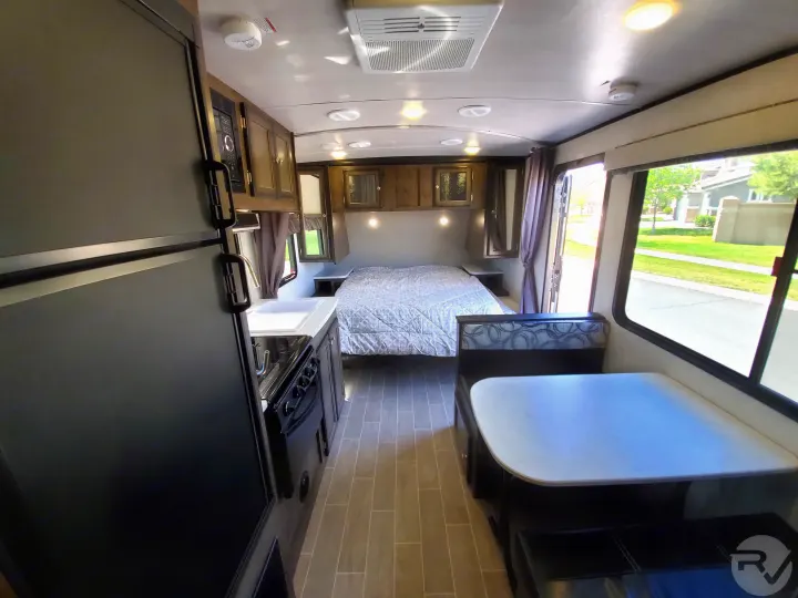Bright RV rental interior features a functional kitchen, comfortable bedroom, and spacious dinette area.. Heartland Wilderness 2020