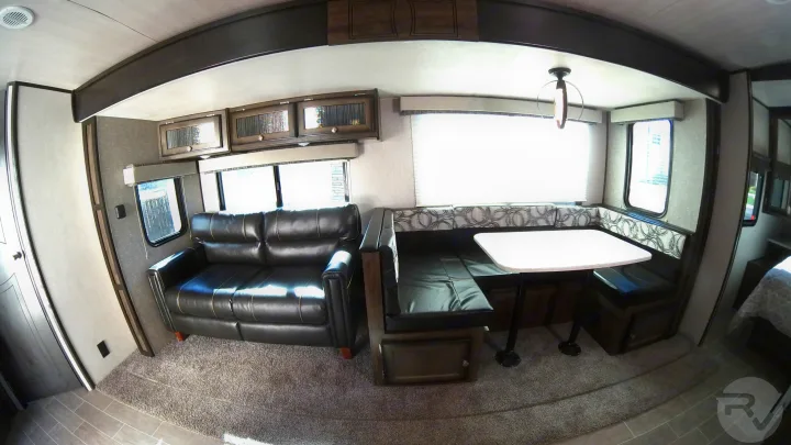 Rv rental: This cozy interior features a black leather couch and a spacious dinette with a white table, ideal for your travels.. Heartland Wilderness 2020