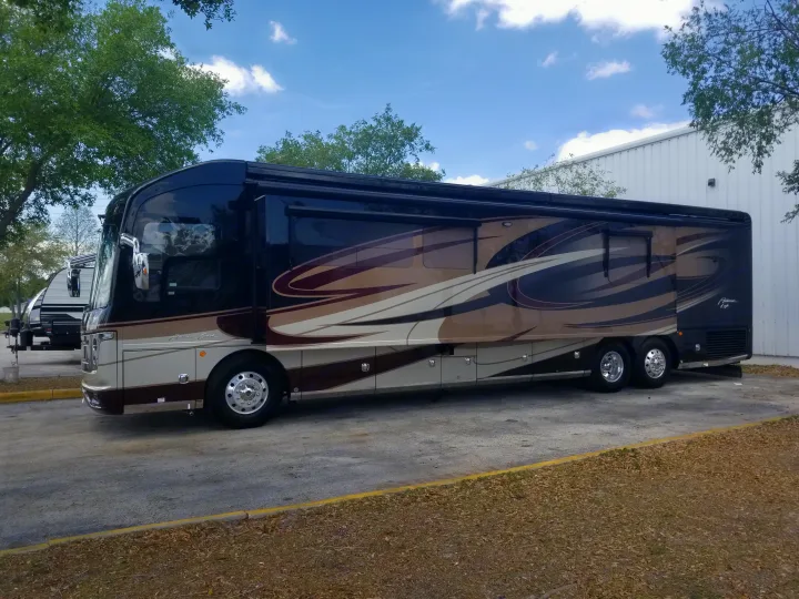 Luxury American Coach RV rental, black and beige with unique swirl design, parked outdoors.. Fleetwood American Eagle 2019