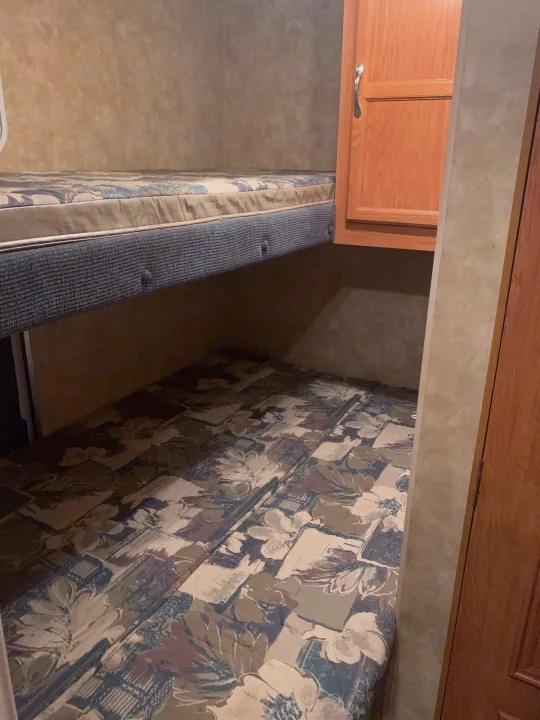 Compact RV rental bunk beds, offering a cozy sleeping area for your travels. Features patterned mattresses.. Jayco Jay Flight 2007