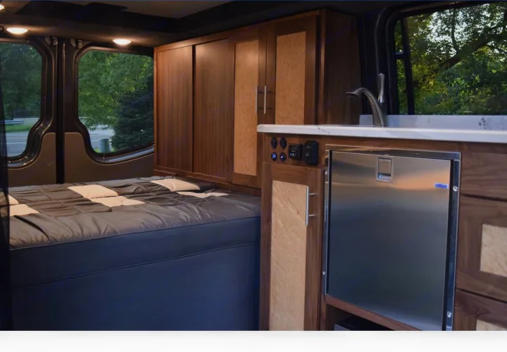 Experience comfort in this rv rental. Features a spacious bed, compact kitchen with fridge & sink, and custom storage.. Mercedes-Benz Sprinter 2016