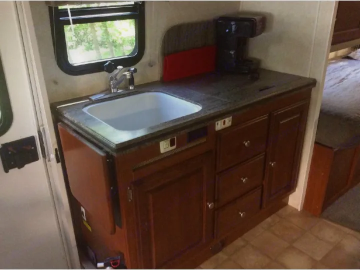 Functional RV rental kitchen features a sink, countertop with coffee maker, cabinets, and a convenient fold-down extension.. Phoenix USA Cruiser 2552 2011